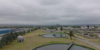 飞越污水处理的圆形水箱。周围道路上的交通。南非伊丽莎白港
