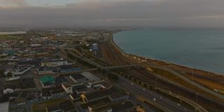 公路和铁路沿海岸延伸。黄昏时分城市交通基础设施的鸟瞰图。南非伊丽莎白港