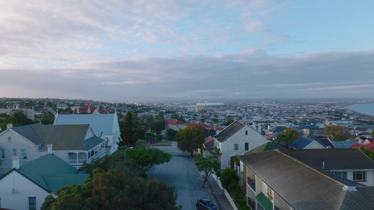 城市沿街的彩色屋顶住宅。向前飞在城市街区上方，展现城镇的全景。南非伊丽莎白港