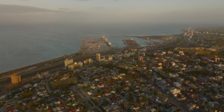 沿海工业和物流基地的滑动和平移镜头。港口和周边地区的晚间航拍画面。南非伊丽莎白港