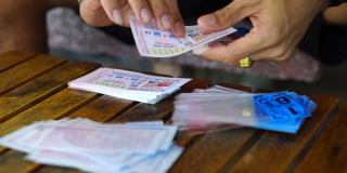 亚洲男子把政府彩票装在塑料信封里视频素材模板下载