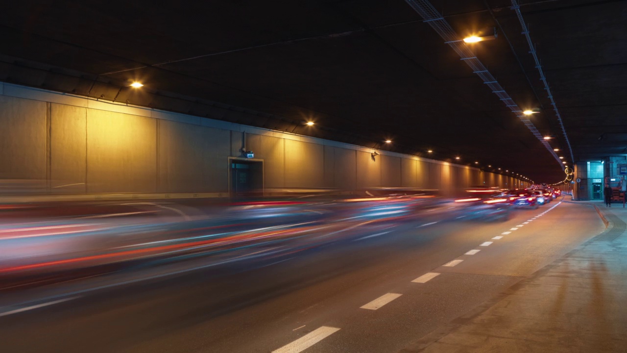 现代大城市夜间广角延时交通堵塞地下通道道路、隧道地下通道道路。繁忙公路的时间间隔。车流高峰时行驶，车灯紧跟着快速移动