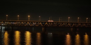 横跨一条宽阔河流的长桥的夜景