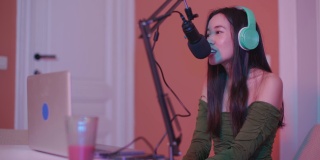 在现场直播期间，一名亚洲女孩录制播客，对着麦克风讲话