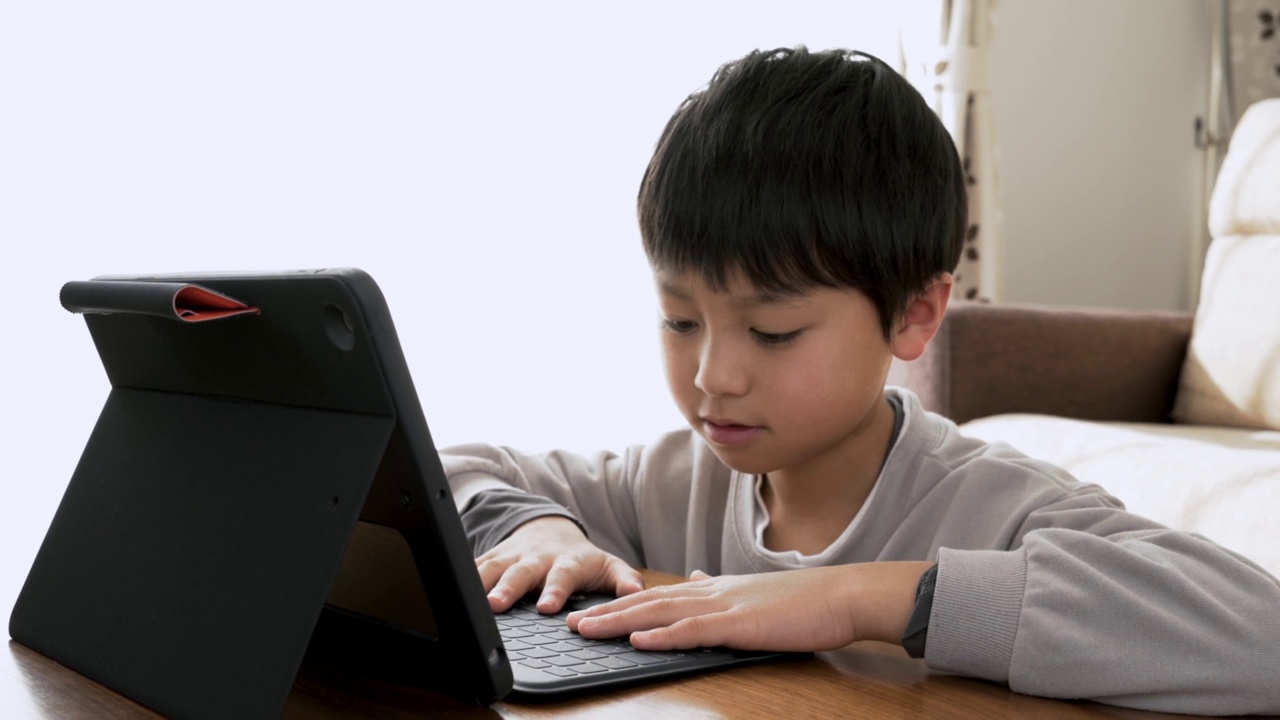 亚洲男孩在家用平板电脑学习