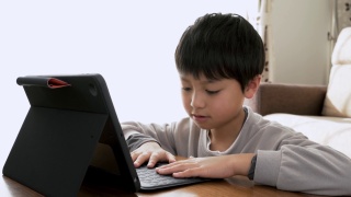 亚洲男孩在家用平板电脑学习视频素材模板下载
