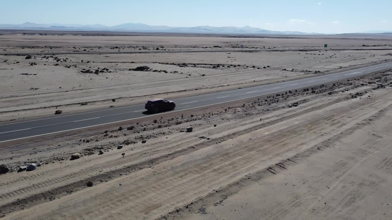 跟随一辆汽车，无人机拍摄的汽车行驶在阿塔卡马沙漠，世界上最干燥的非极地沙漠，智利，南美洲。