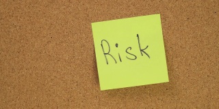 把“风险”标签贴在软木板上。俯视图的笔记板。办公室里满是记录。在办公室或家里留下提醒。