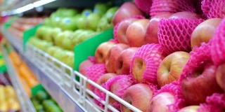 近距离观看超市货架上五颜六色的苹果品种，维生素水果杂货店购物。出口不同品种的苹果至各商店及超级市场