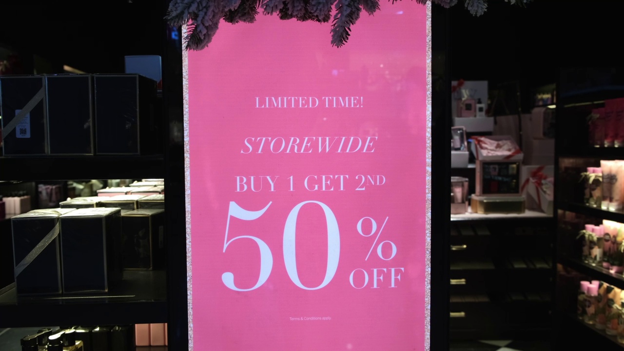 时装店展示的大粉色购物海报，服装和配饰的折扣优惠。50%的折扣吸引了大量的买家来进行有利可图的购买