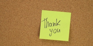 把“谢谢，谢谢”贴在软木板上。俯视图的笔记板。办公室里满是记录。在办公室或家里留下提醒。