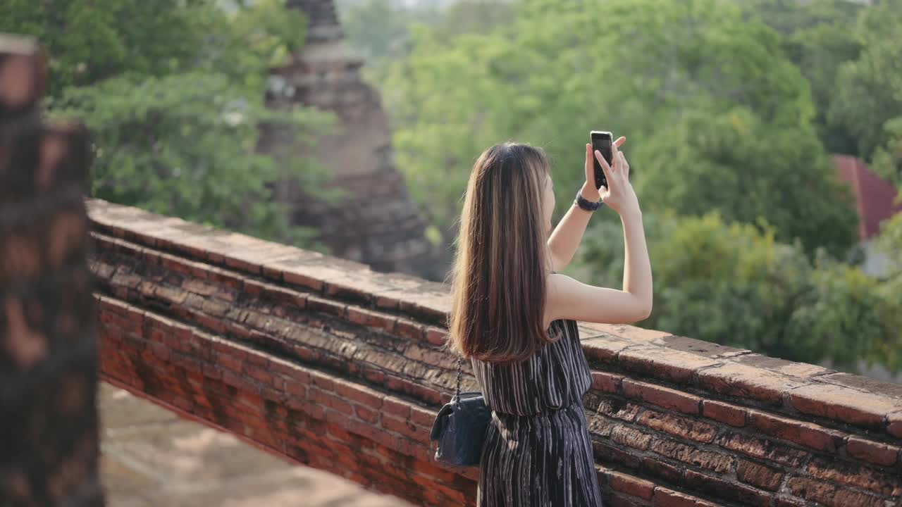 5G连接生活方式年轻的中年亚洲人幸福乐趣独自旅行女人探索冒险在大城府最著名的寺庙