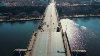 电影镜头拍摄了许多人观看河上吊桥的下降