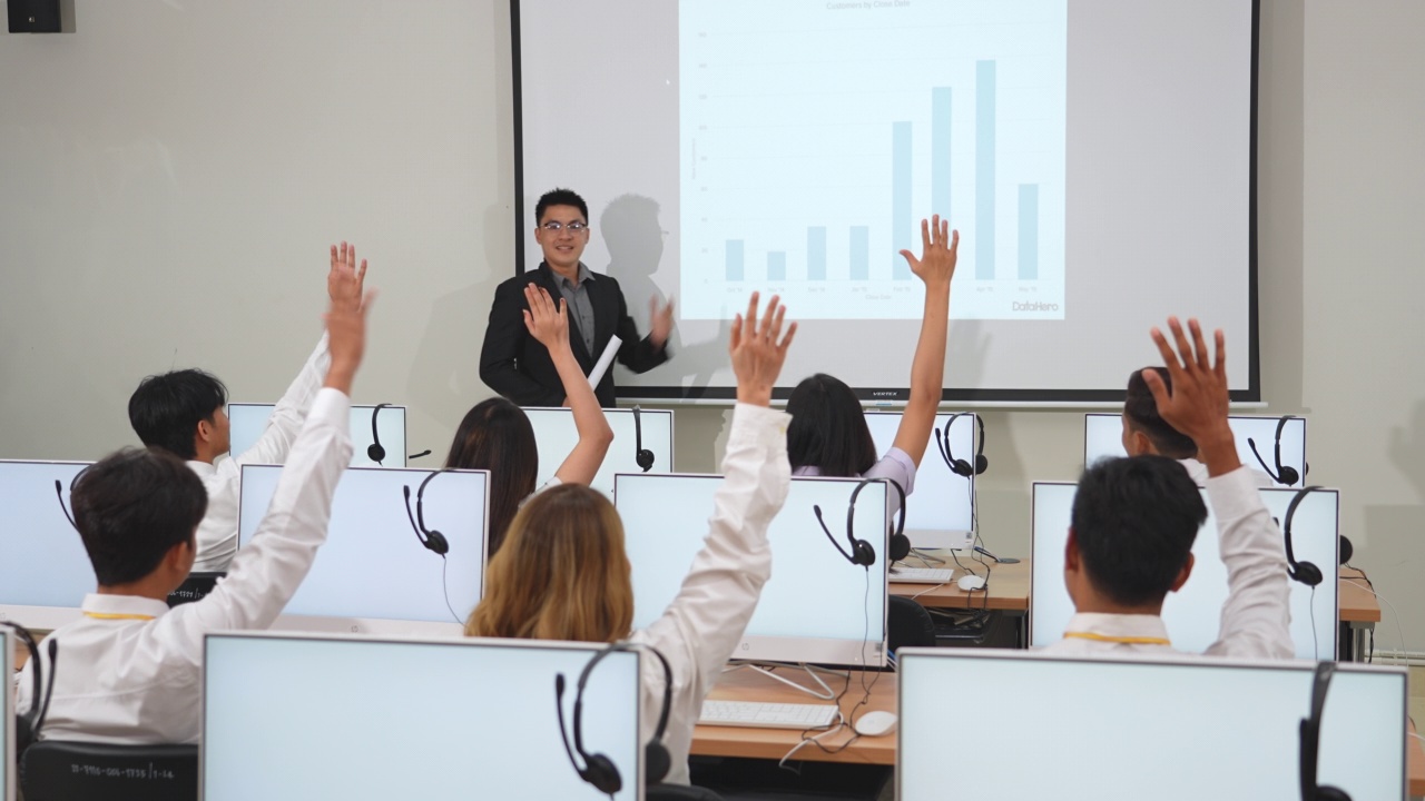 在大学的计算机教室里，成熟的教师与多种族的学生进行教学