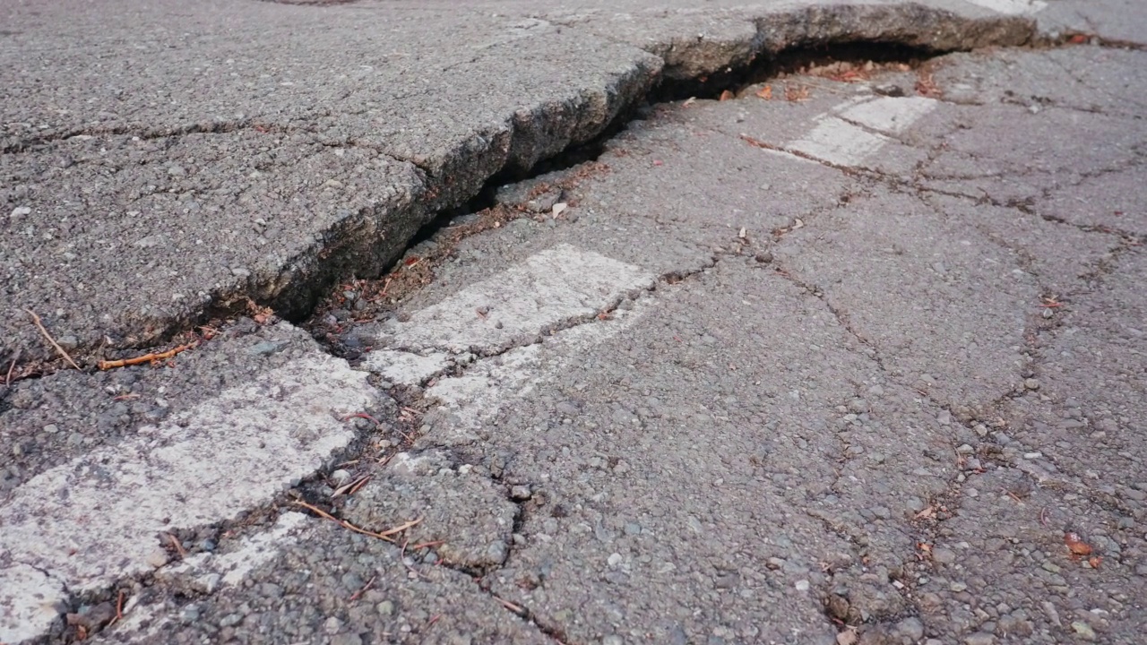 道路标记旁边的公路被深深的裂缝破坏了