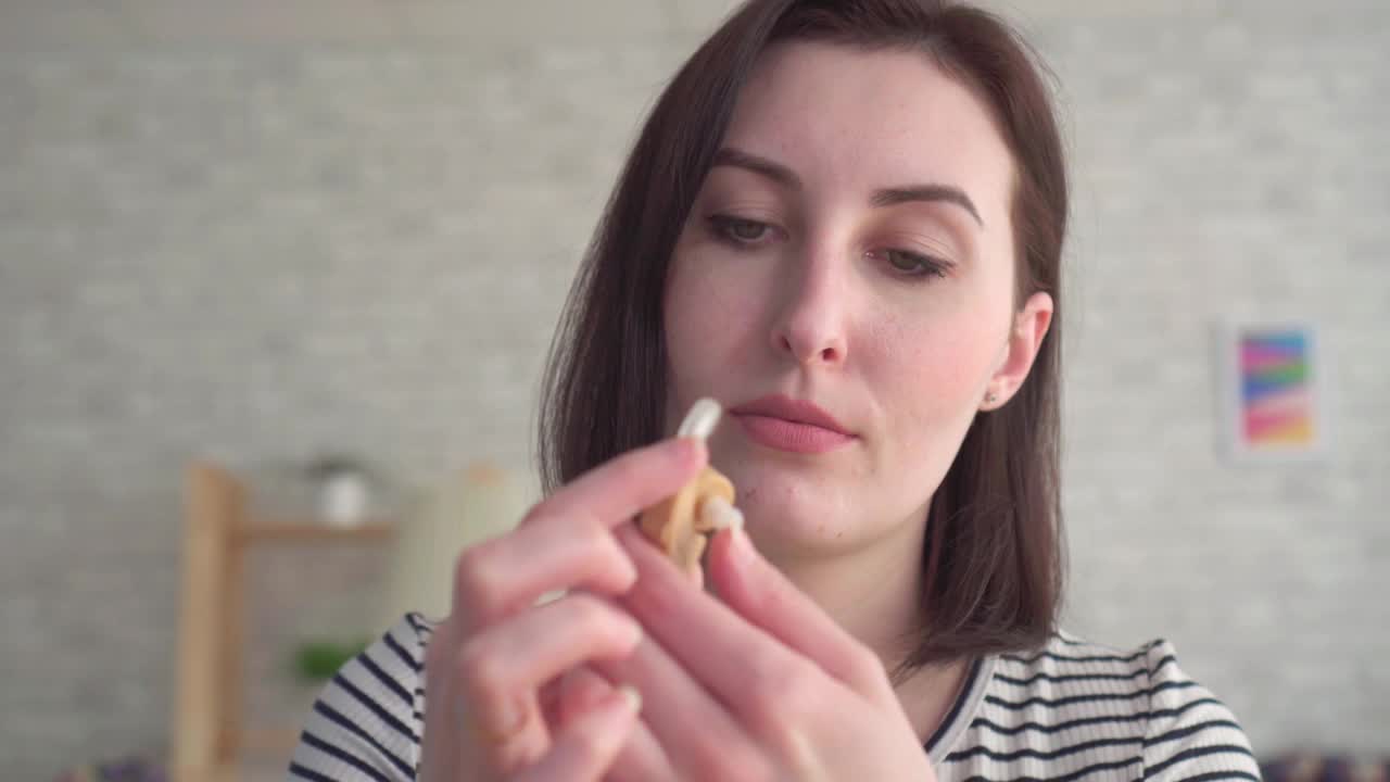 听力不好的年轻女子将助听器插入耳朵