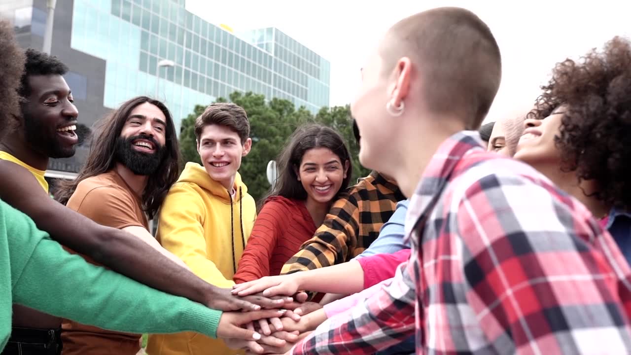 详情图-一群在户外的多种族朋友聚在一起鼓掌，年轻的多元团队在户外玩手叠