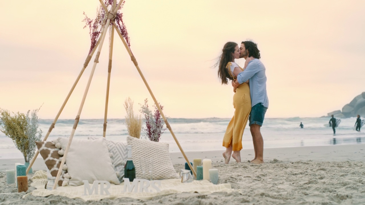 一对幸福的年轻情侣在求婚后在海滩上拥抱。一对相爱的男女，亲吻并庆祝他们的订婚