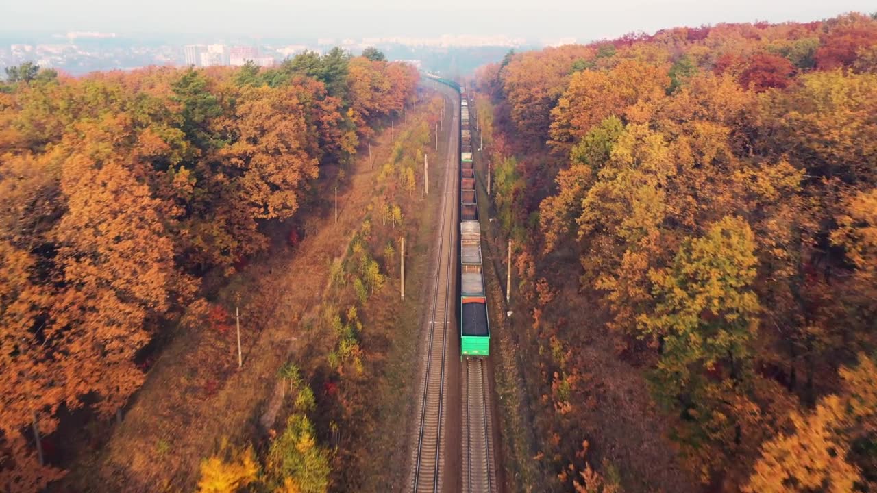 詳情圖-貨運列車在美麗的森林在霧在日出在秋天。鳥瞰圖，秋天的貨車和貨物。工業(yè)。俯視鐵路，霧蒙蒙的樹，橘黃色的葉子?；疖囌?></div><div   id=