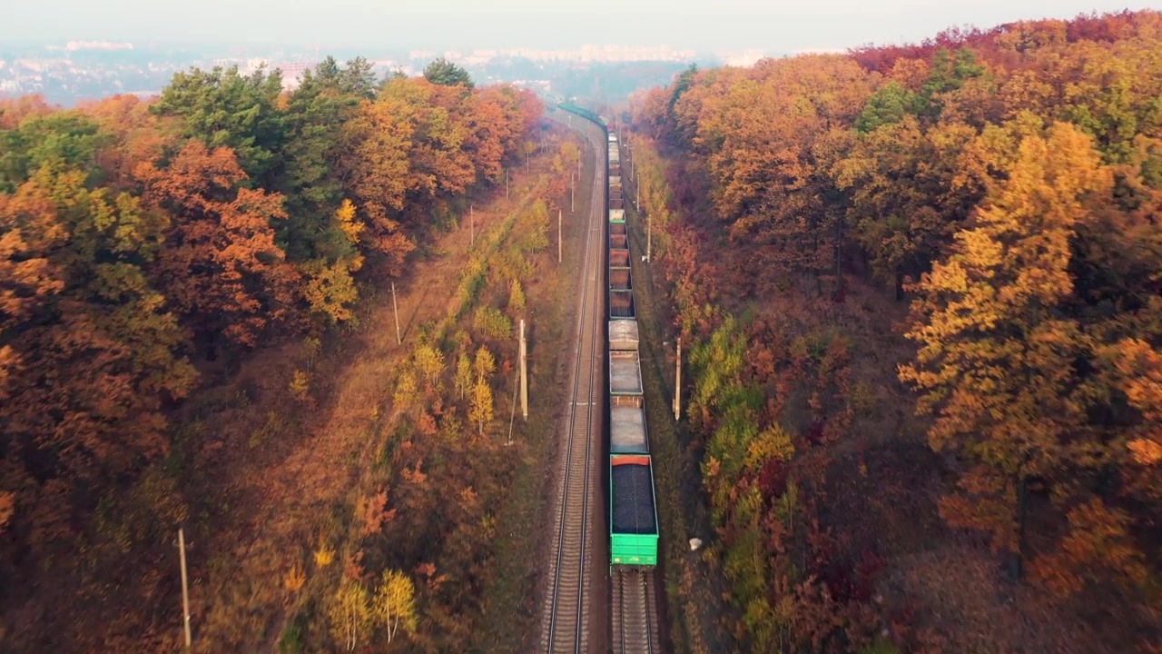詳情圖-貨運列車在美麗的森林在霧在日出在秋天。鳥瞰圖，秋天的貨車和貨物。工業(yè)。俯視鐵路，霧蒙蒙的樹，橘黃色的葉子?；疖囌?></div><div   id=