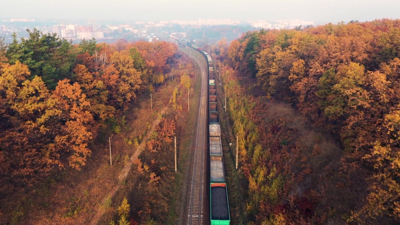 詳情圖-貨運列車在美麗的森林在霧在日出在秋天。鳥瞰圖，秋天的貨車和貨物。工業(yè)。俯視鐵路，霧蒙蒙的樹，橘黃色的葉子?；疖囌?></div><!--]--></div></div><div   id=