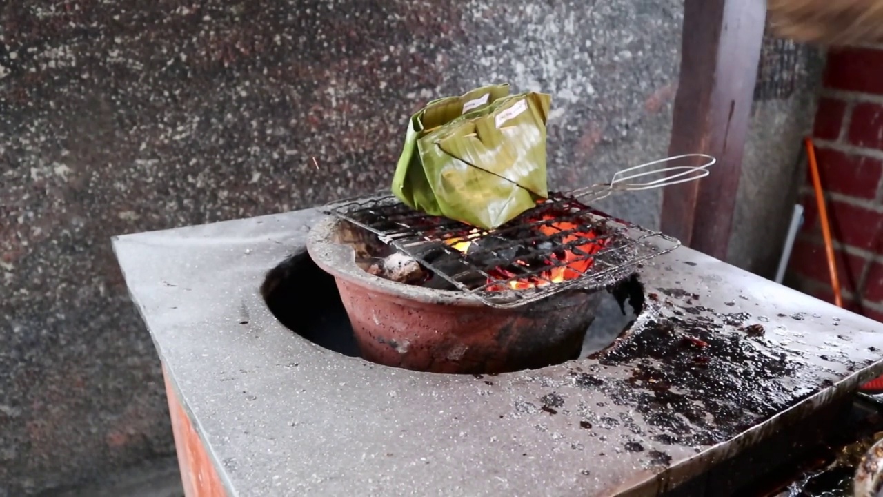 “Nasi Bakar”或香蕉叶包裹的米饭在炉子上燃烧