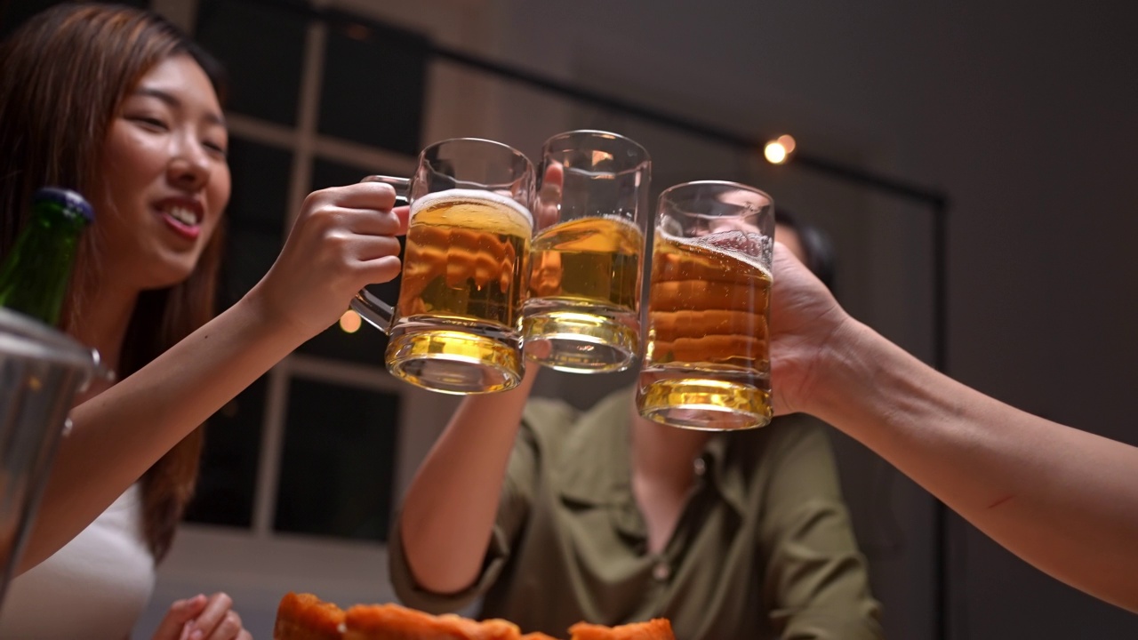 亚洲朋友在庆祝节日，他们碰杯啤酒