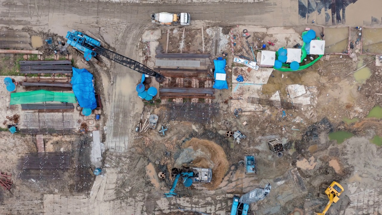 详情图-高角度空中自顶向下无人机视角的时间推移在大型建筑施工现场与许多巨大的起重机和机械车辆白天工作。