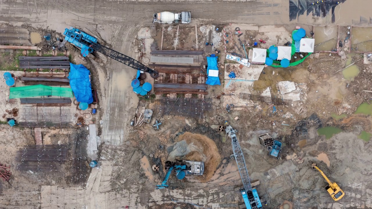 详情图-高角度空中自顶向下无人机视角的时间推移在大型建筑施工现场与许多巨大的起重机和机械车辆白天工作。
