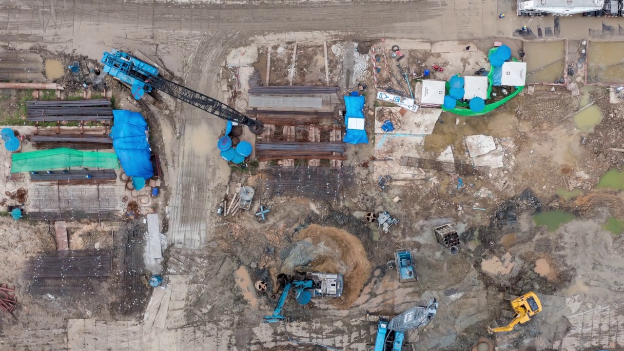 详情图-高角度空中自顶向下无人机视角的时间推移在大型建筑施工现场与许多巨大的起重机和机械车辆白天工作。