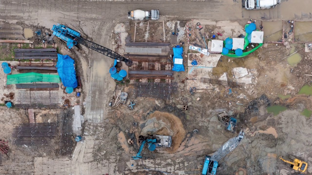 详情图-高角度空中自顶向下无人机视角的时间推移在大型建筑施工现场与许多巨大的起重机和机械车辆白天工作。