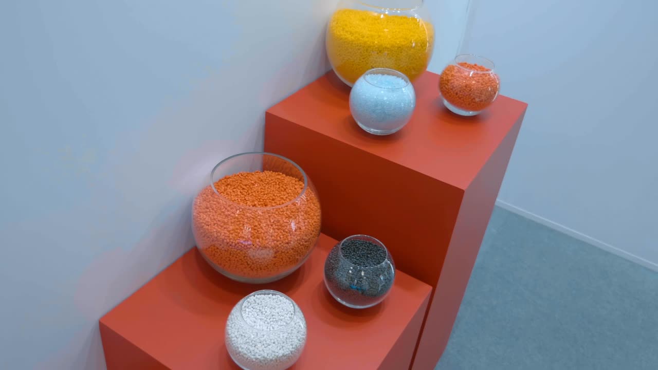 在玻璃球容器中，不同颜色的塑料颗粒样品