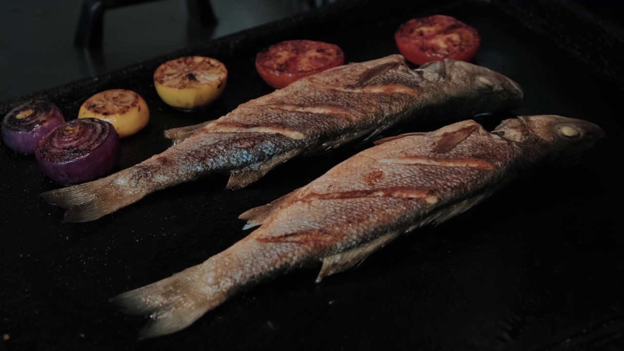 海鲜餐厅晚餐烤制鲈鱼。烹饪