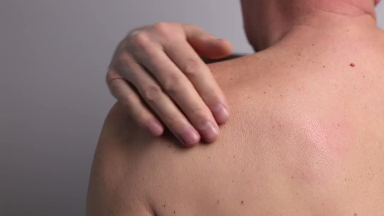肩痛及触发点。男子近距离按摩疼痛的身体部位