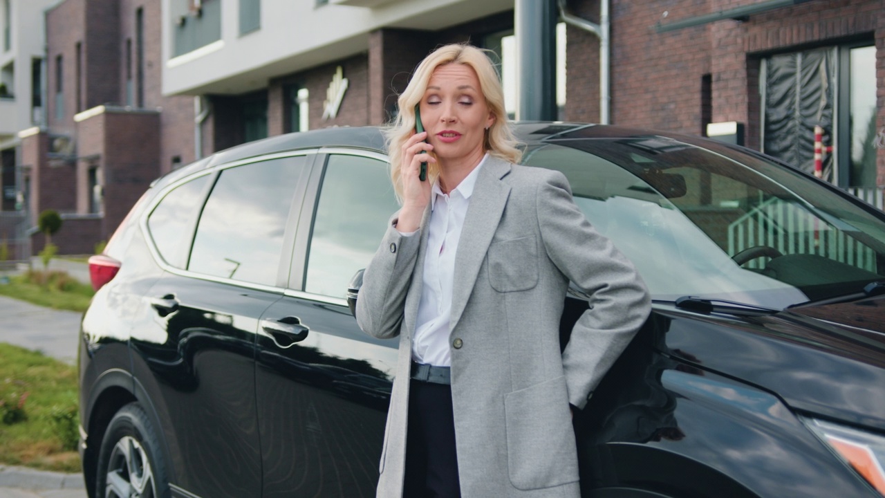商務(wù)自信的女人在車外打電話。技術(shù)與人的概念