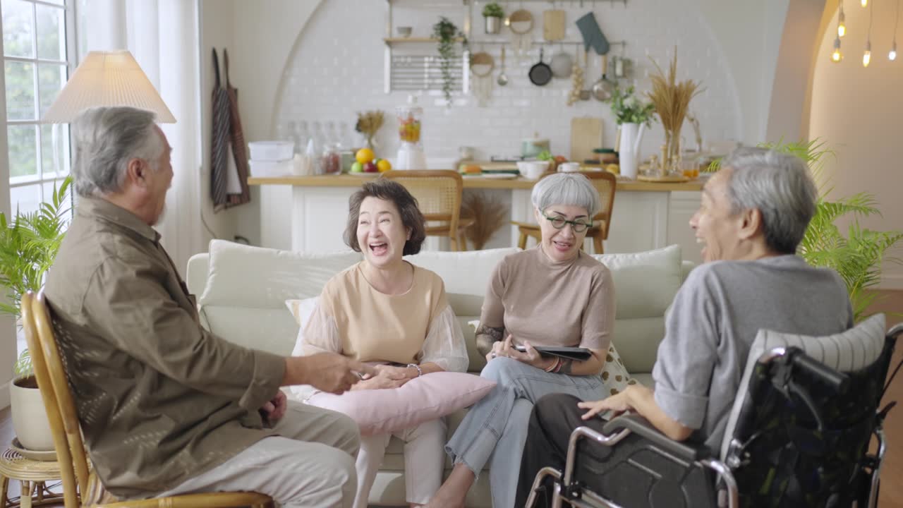 详情图-一群亚洲老人朋友一起坐在家里的客厅里，享受着聊天的乐趣。