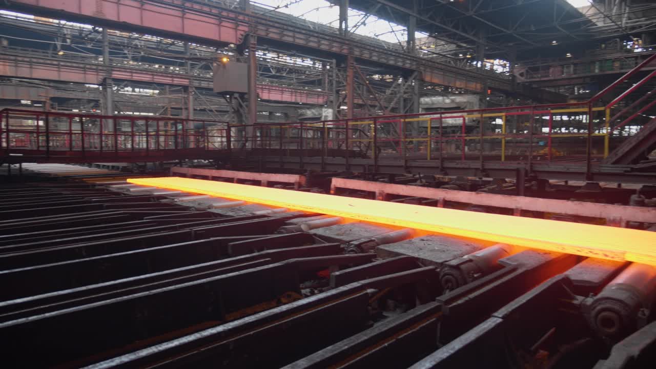 冶金工厂的金属生产过程。一个分开的钢坯沿着传送带移动。冶金工厂。滚动商店。经营理念，现代钢铁生产技术