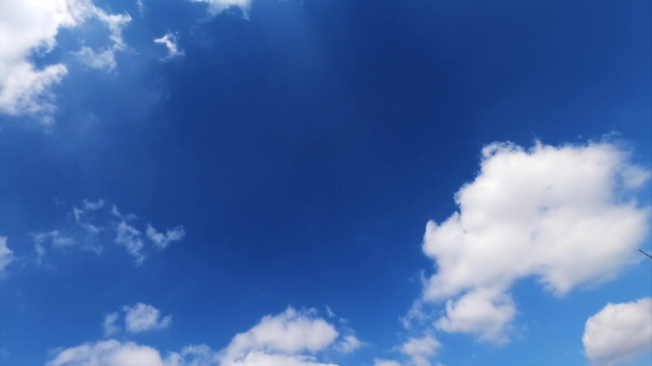 詳情圖-淡淡的白云在明亮的藍(lán)天上迅速地漂浮著。蓬松的云朵反射著夏日陽光的光芒。