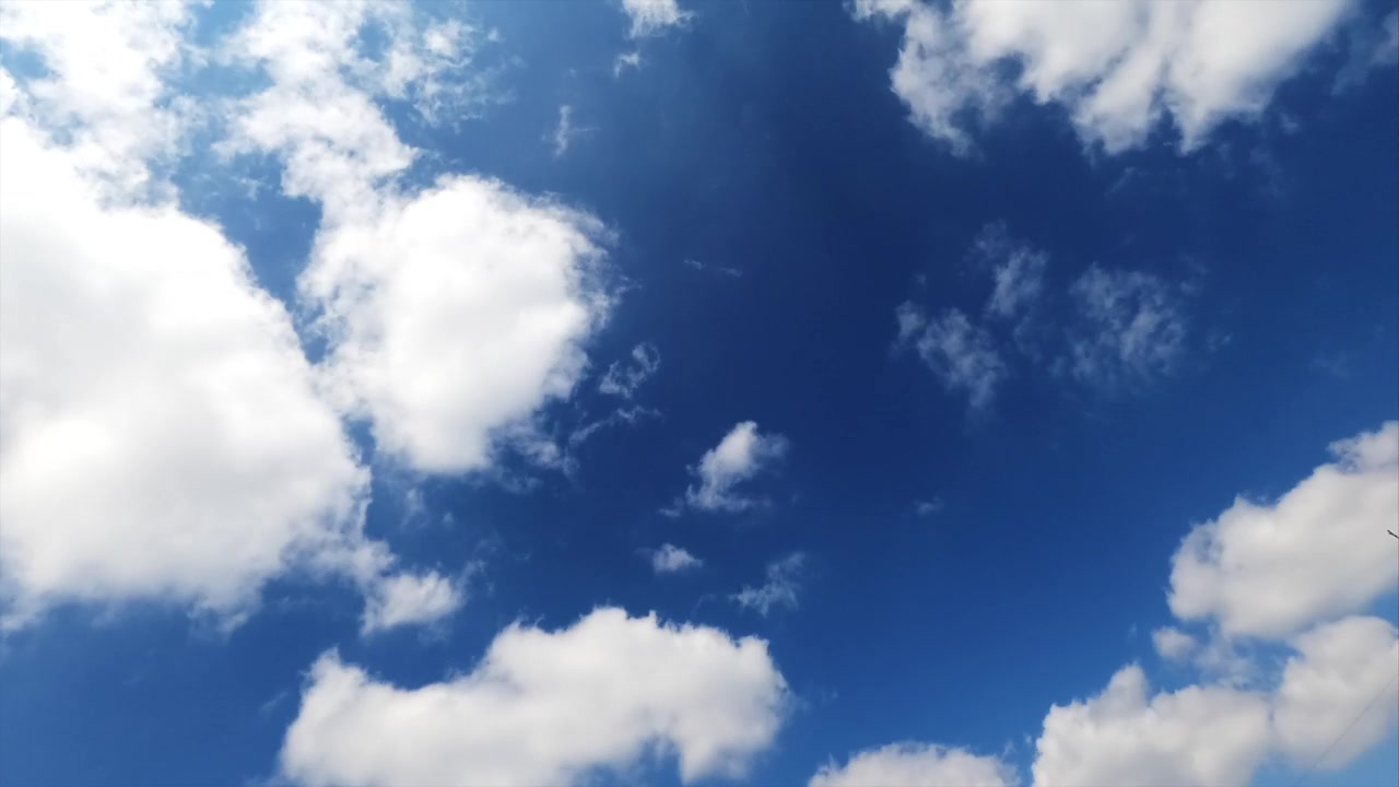 詳情圖-淡淡的白云在明亮的藍(lán)天上迅速地漂浮著。蓬松的云朵反射著夏日陽光的光芒。