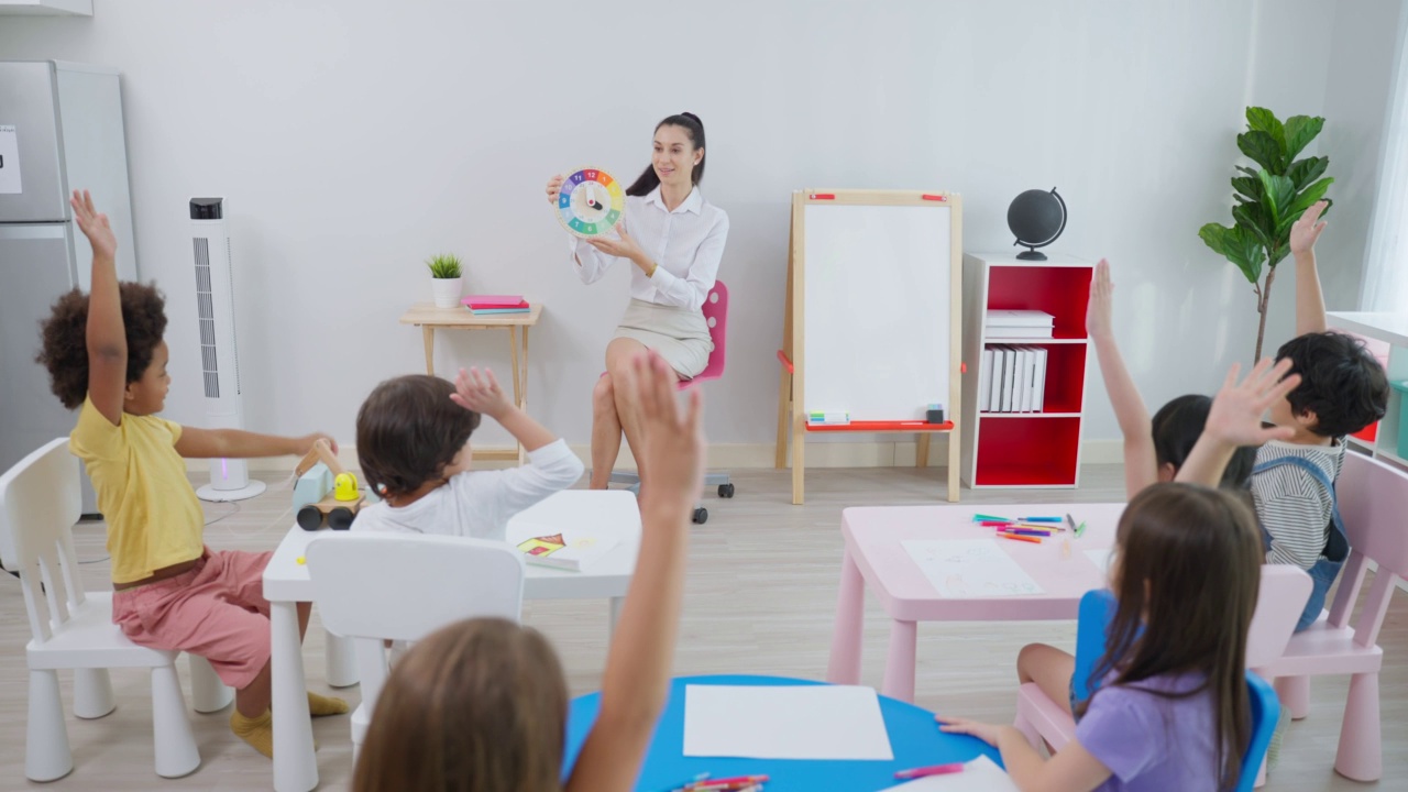 白种人美女老师在学校给孩子上课。幼稚园迷人的女教师大师在课堂上用有趣的活动讲解教育孩子们的学生。