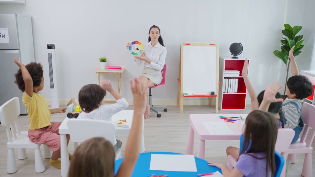 詳情圖-白種人美女老師在學(xué)校給孩子上課。幼稚園迷人的女教師大師在課堂上用有趣的活動講解教育孩子們的學(xué)生。
