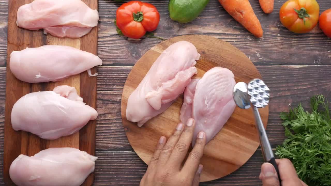 在砧板上加工生鸡胸肉