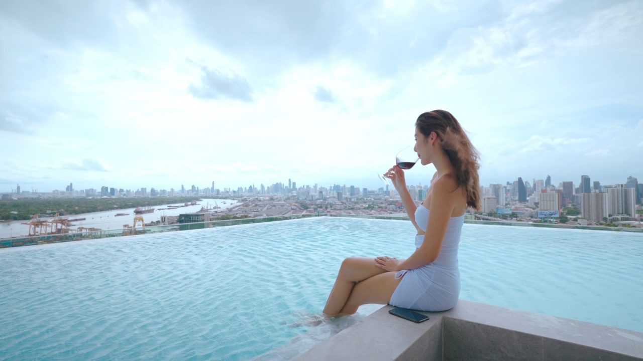 迷人的美丽女人放松在游泳池。