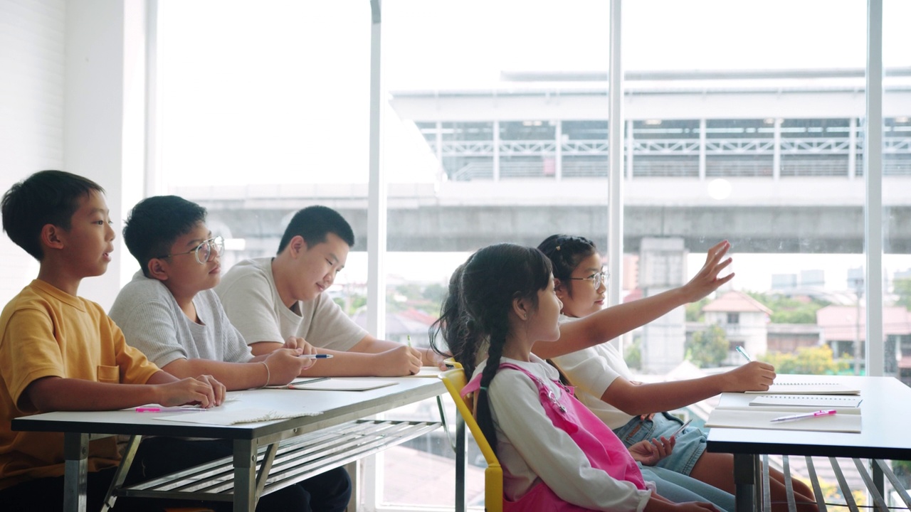 小学生在课堂上举手提问。