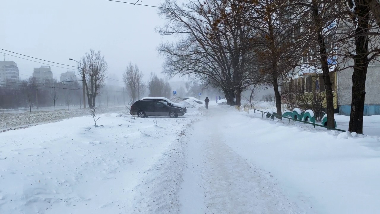 雪在城市的道路上与汽车一月