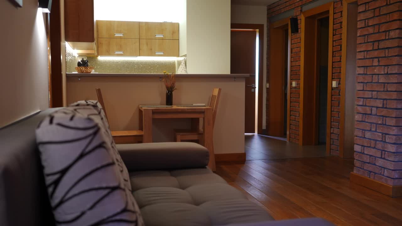 生態(tài)度假酒店客房側(cè)景柔軟舒適的沙發(fā)，背景是舒適的小廚房。旅游勝地內(nèi)部，沒有人在里面。