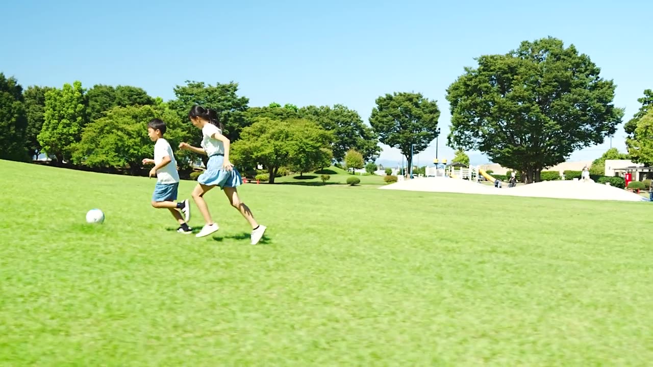 详情图-亚洲孩子在蓝天下的公园里踢足球
