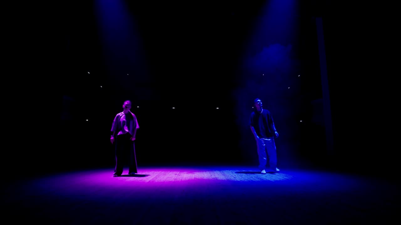 舞台上的街舞表演，两位少年正在积极地跳舞，现代舞风格