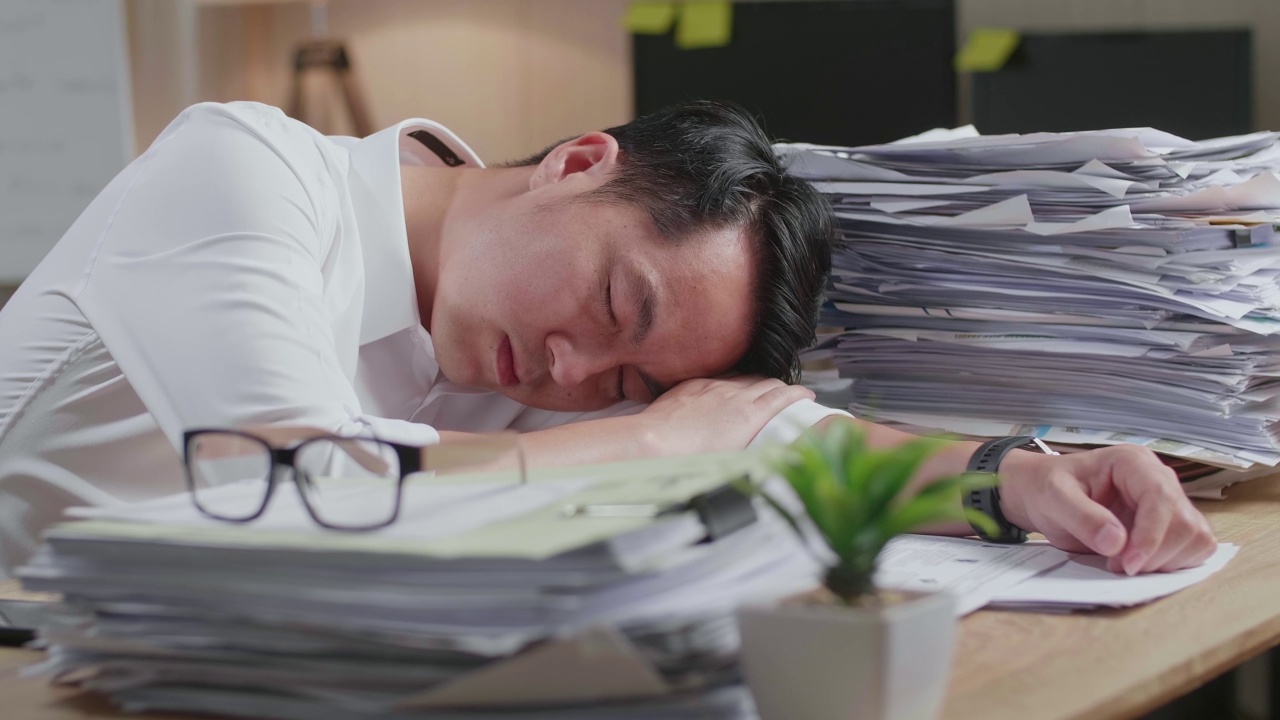 详情图-疲惫的亚洲人由于在办公室努力工作文件睡觉的特写