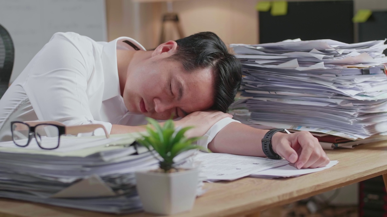 详情图-疲惫的亚洲人由于在办公室努力工作文件睡觉的特写
